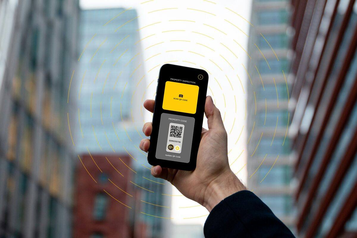 A TELtag asset record open on a smartphone, radiating a connected-signal pattern.